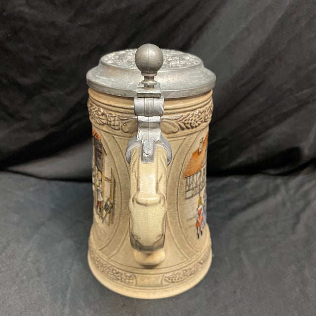 Nostalgic German beer stein featuring an 18th/19th Century village scene. One of more than 100 collectible steins for sale...