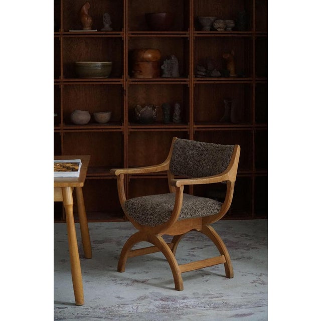 A fine and elegant armchair in solid oak, reupholstered in quality shearling lambswool. Designed by henning (henry)...