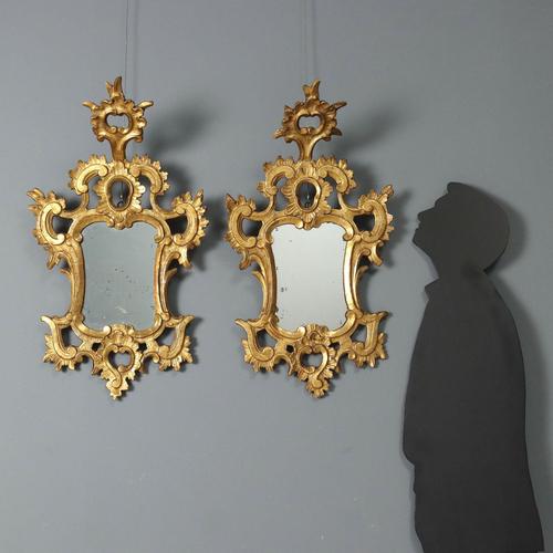 Pair of small carved and gilded wooden mirrors. Frame with openwork carvings of scrolls, leaves, and curls; mercury...
