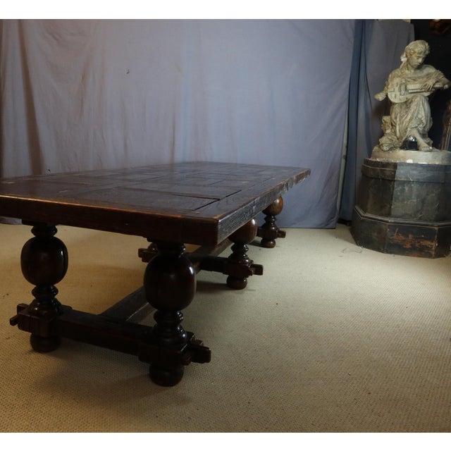 A very large oak table with six baluster legs in the Renaissance style. The top is parquet-patterned and the legs are...