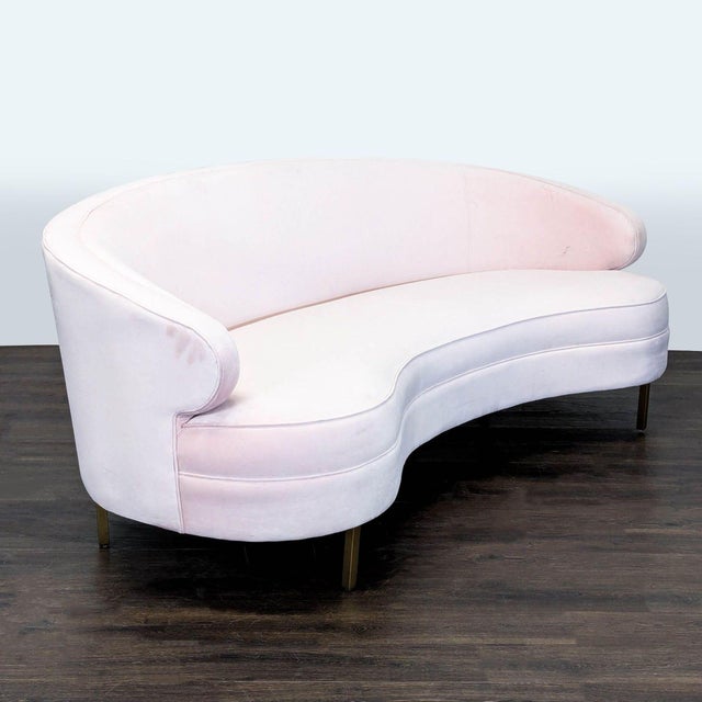 This Safavieh 3-seat sofa features a unique curved design and soft pink velvet upholstery, adding a modern and elegant...