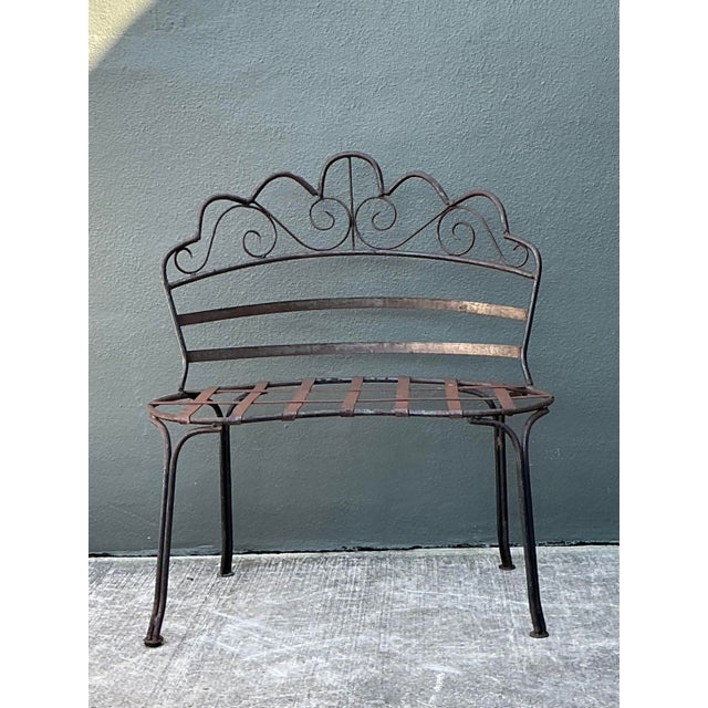 This vintage wrought iron garden bench is a charming example of French Provincial-inspired outdoor design. Hand-crafted...