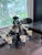An impressive two-tier wrought iron chandelier with 12+ frosted cream glass bell shades and elegant scrollwork throughout....