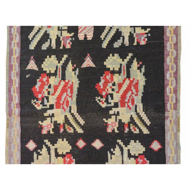 A wonderful early 20th century Turkish Bessarabian Kilim rug with ten stylized floral medallions woven in crimson, pink,...