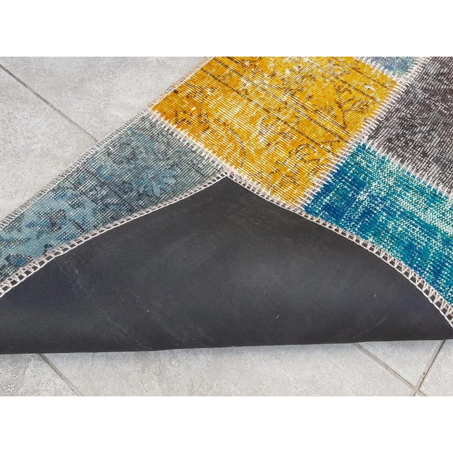 This is a vintage Turkish Oushak rug from the Mid 20th Century. The piece was hand-knotted.