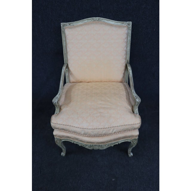 Light peach/pink Country French bergeres in ornate cream carved frames with antiqued finish with down filled cushions.