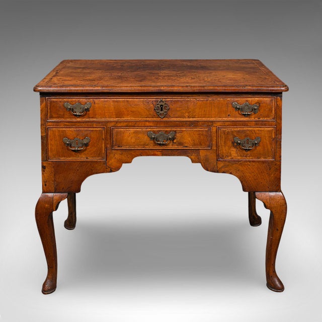This is an antique lowboy. An English, walnut correspondence or scholar's table, dating to the Georgian period, circa...