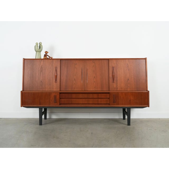 The highboard was made in the 1970s, Danish production. The structure is covered with teak veneer. The legs are made of...