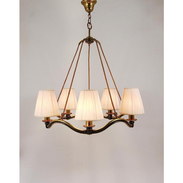This exquisite 29“ diameter brass chandelier exemplifies the elegance of Viennese Modernism from the 1940s, designed by...