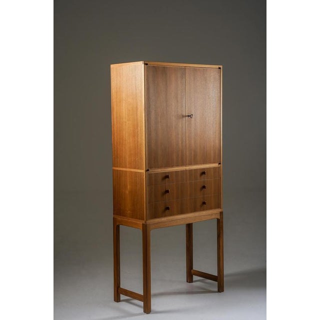 Elegant cabinet in walnut, model “Lillbo” designed by Carl Malmsten. The piece is raised on slender legs, giving it a...