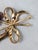 1950s goldtone two molded purple glass flowers with faux-pearl dangles centers with a bow around the stems brooch with...