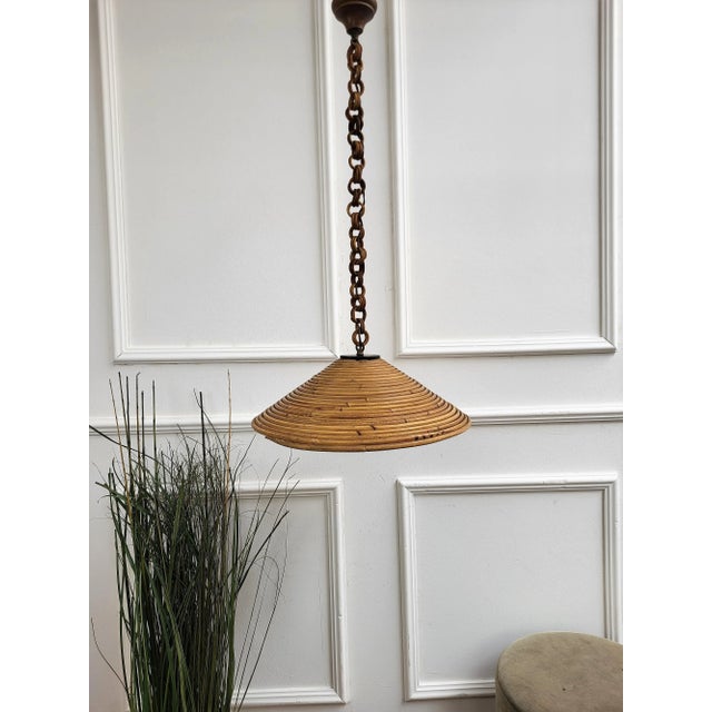 Eyecatching Italian 1960s handcrafted rattan pendant light with circular design. This suspension lamp has a bell shaped...