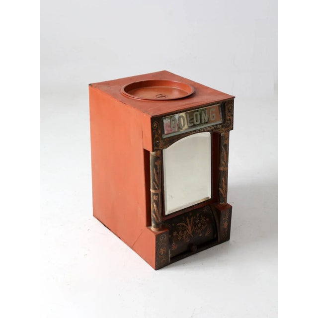 An antique Victorian mercantile tea bin with impressive scale and distinctive graphic presence. Crafted in tin, the...
