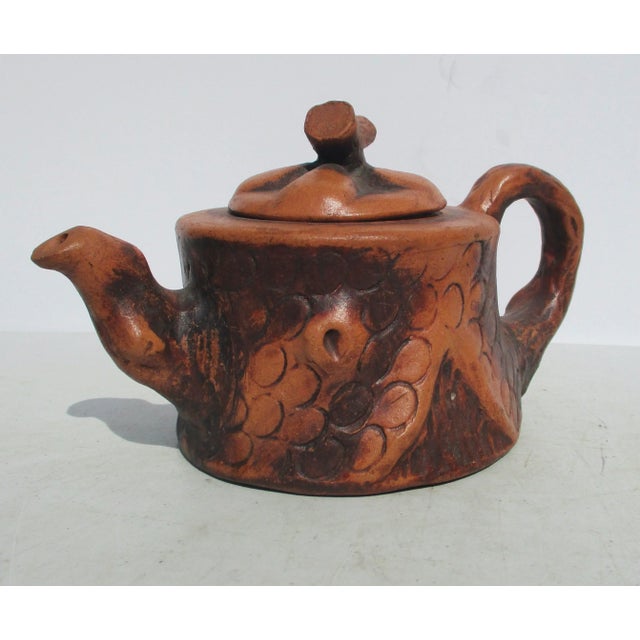Handmade teapot in the style of Yixing with bark and tree-formed handles. Red clay with carved and impressed tree...