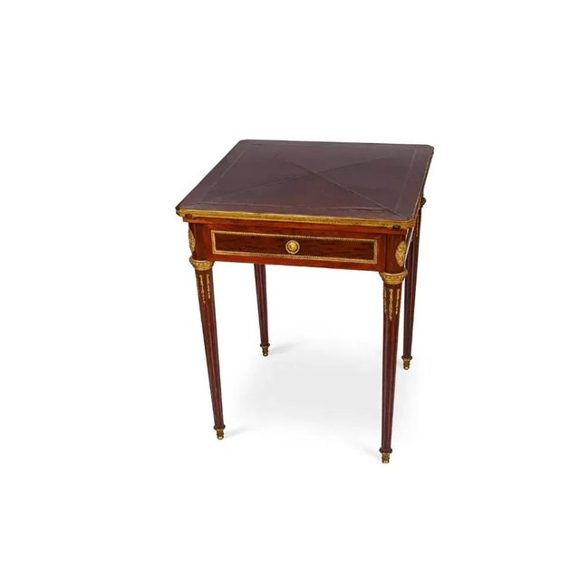A French Antique Ormolu-Mounted mahogany envelope games card table, C. 1870, attributed to Henry Dasson. A very elegant...