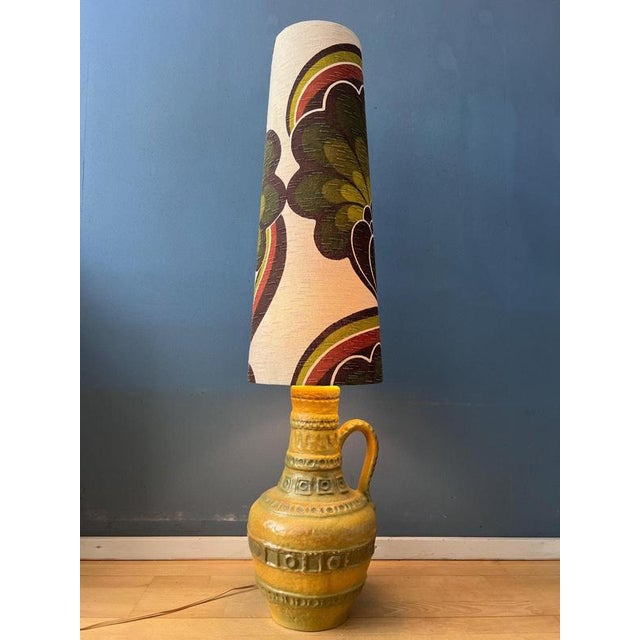 A striking west germany space age floor lamp, featuring a vibrant green ceramic base paired with a newly made textile...