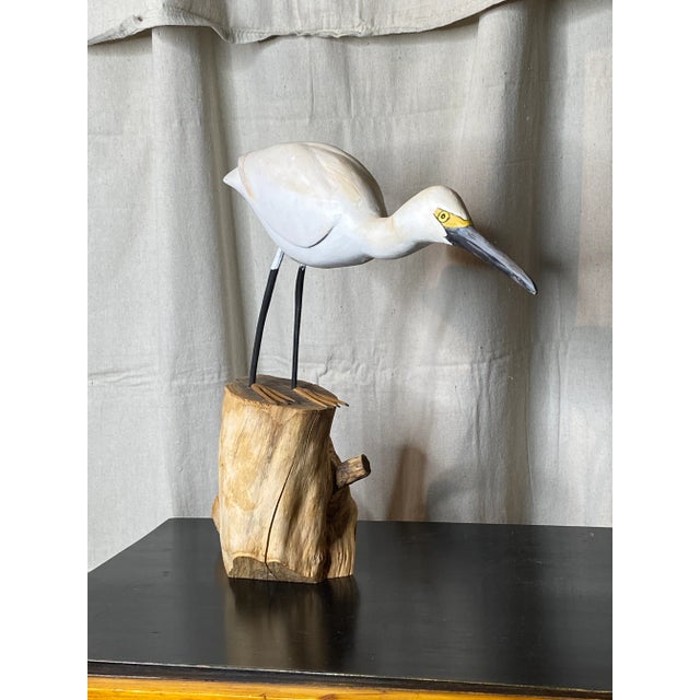 Vintage hand painted and carved shore bird (likely a crane), sitting atop a natural trunk on metal legs.