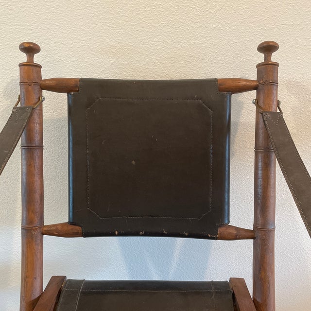 Faux bamboo and brown leather folding chair from the 20th century with sling arms.