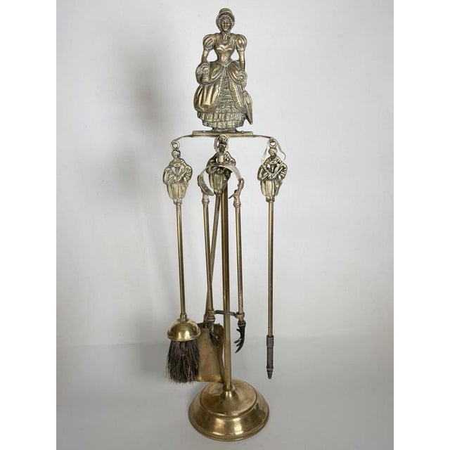 Elegant French fireplace companion set crafted in solid brass during the 1960s. The stand is surmounted by a finely cast...