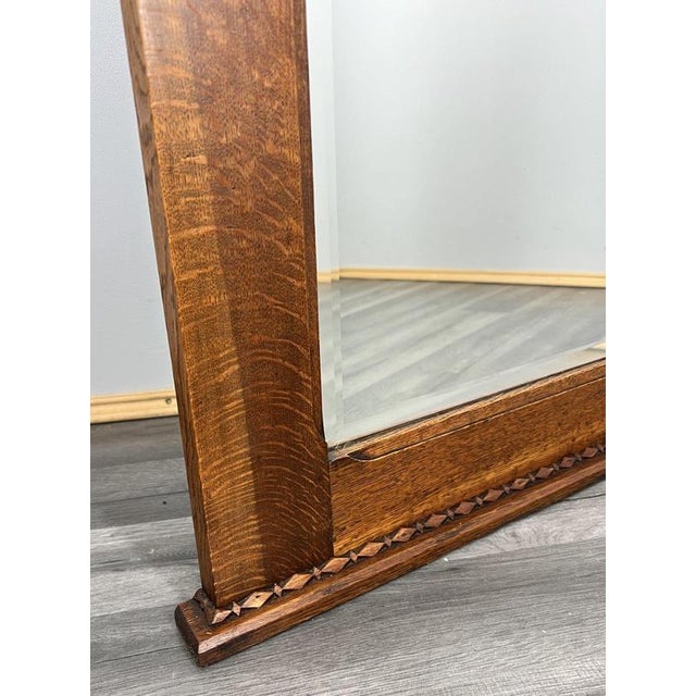 This charming French oak mirror features a beautifully carved panel with a decorative basket motif and warm polished tones...
