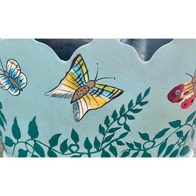A charming vintage toleware cachepot with a rare teal‑turquoise painted ground and hand‑painted butterfly and vine motifs....