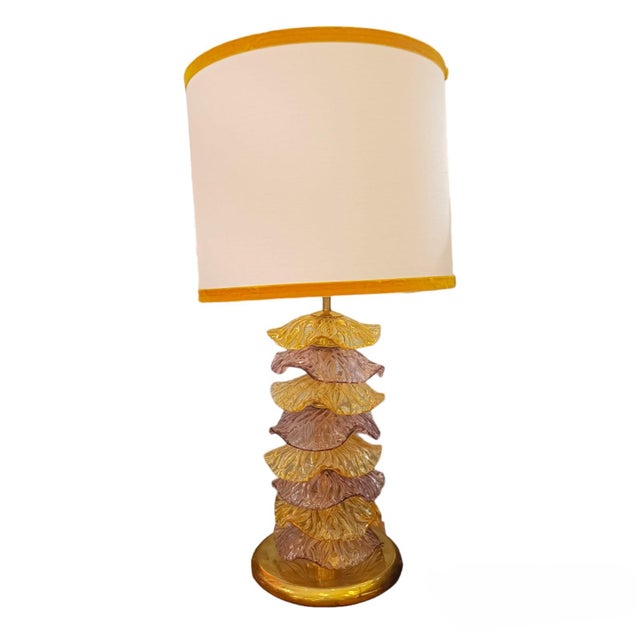 A pair of 1980s-style lamps made with a gilded brass frame, topped with individual Murano glass discs. The gold and mauve...
