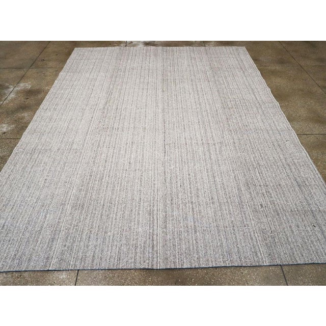 This Mid-20th century Turkish Flatweave Kilim rug, embodies the timeless appeal of Anatolian weaving traditions. Its...