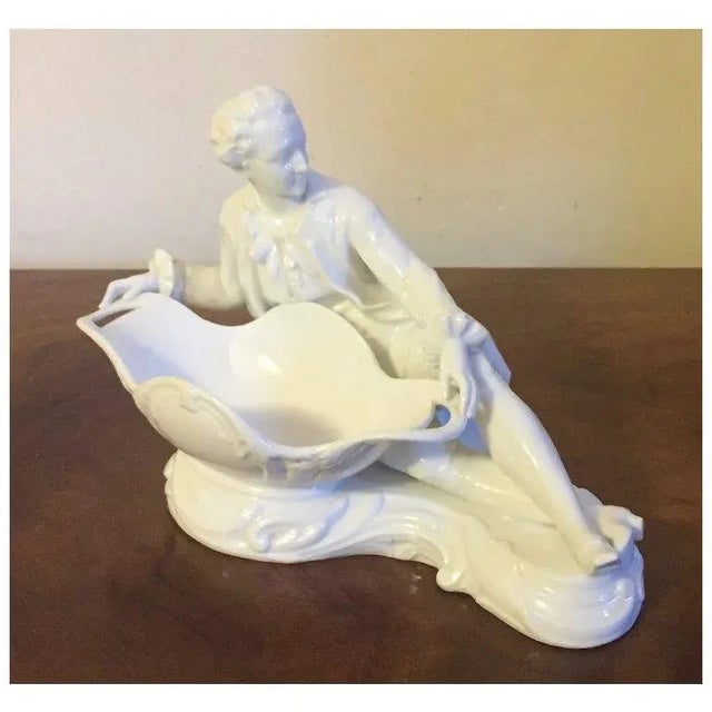 Antique 19th century Meissen porcelain sweetmeat figural centerpiece in blanc de chine. A reclining male figure holds a...