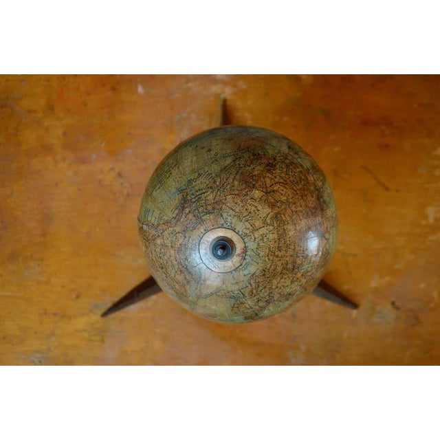 Here is a beautiful invitation to travel, in space as well as in time. This charming antique globe is carried by a thin...