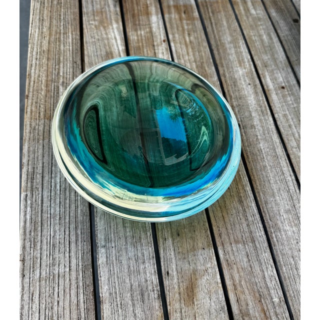 Substantial emerald green cased art glass bowl attributed to Murano, Italy. This striking decorative piece features deep...