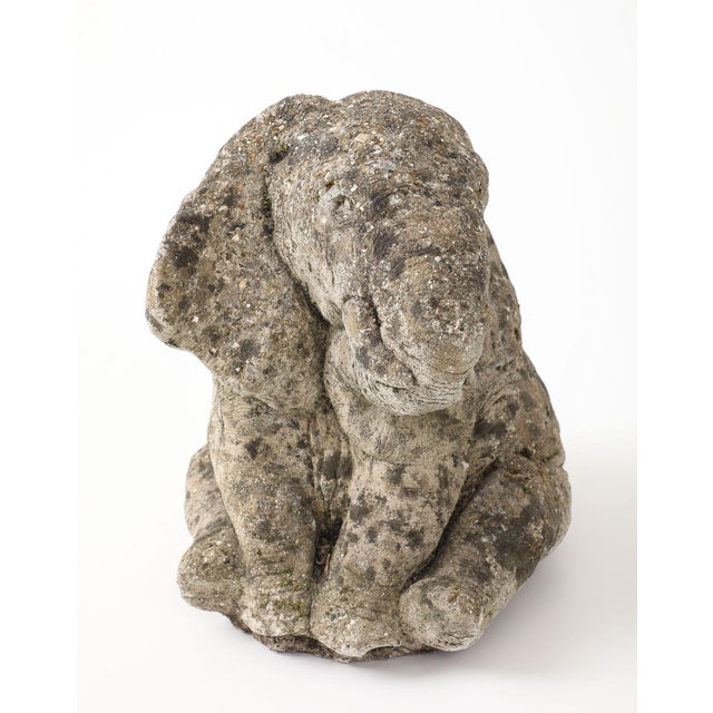 A French mid-20th-century cast stone garden statue depicting a seated elephant with rounded, stylized features and a...