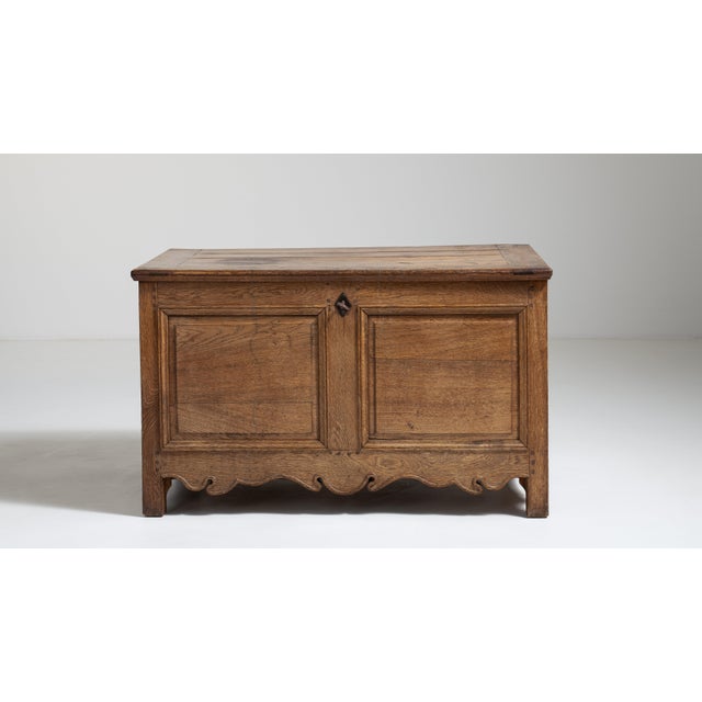 A substantial carved oak trunk reflecting traditional storage forms used before the widespread use of built-in cabinetry....