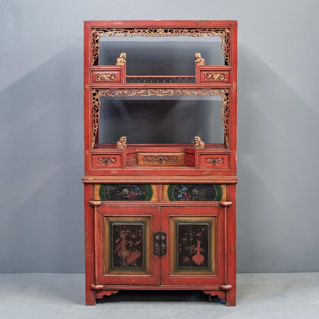 Antique 2 piece Chinese lacquered cabinet painted in a coral red with floral painted panels in black, green and yellow....