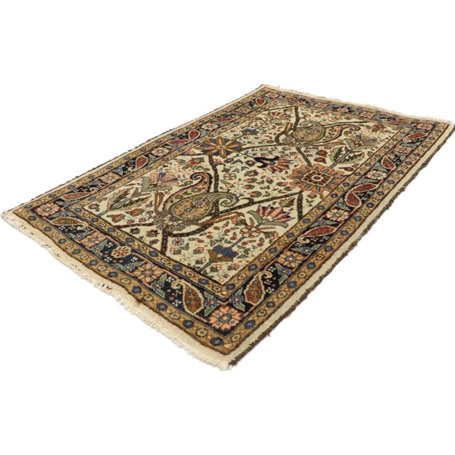 This hand-knotted wool vintage Persian Tabriz rug features an all-over botanical lattice composed of florals, palmettes,...