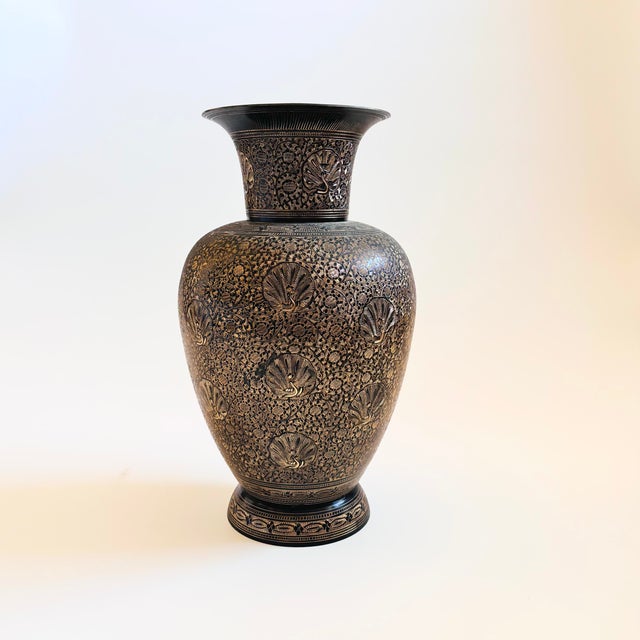 A vintage brass vase with an intricate etched floral design with peacocks to the surface. Black finish with the etched...