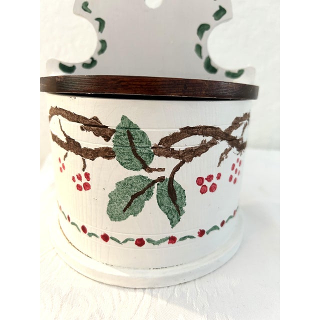 Charming French Country style white wood lidded salt box featuring a hand-painted design on face. Hole at top for hanging.