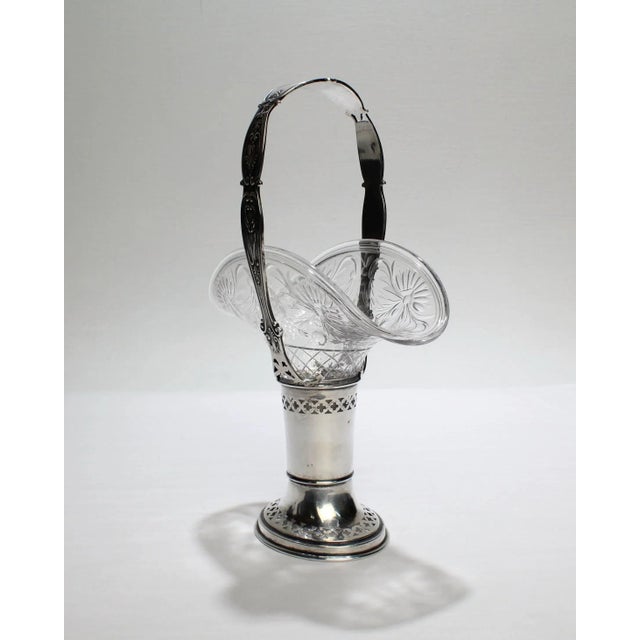 A fine, antique Gorham sterling silver and cut-glass handled basket. The glass insert has etched engraving and the basket...