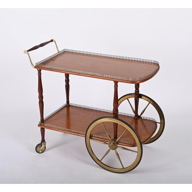 Unique mid-century bar cart in mahogany wood and brass. This fantastic item was designed in Italy during the 1960s. This...