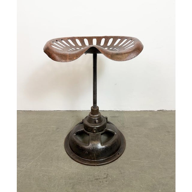 Vintage industrial height adjustable swivel chair from 1950s. An old tractor seat mounted on an iron construction....