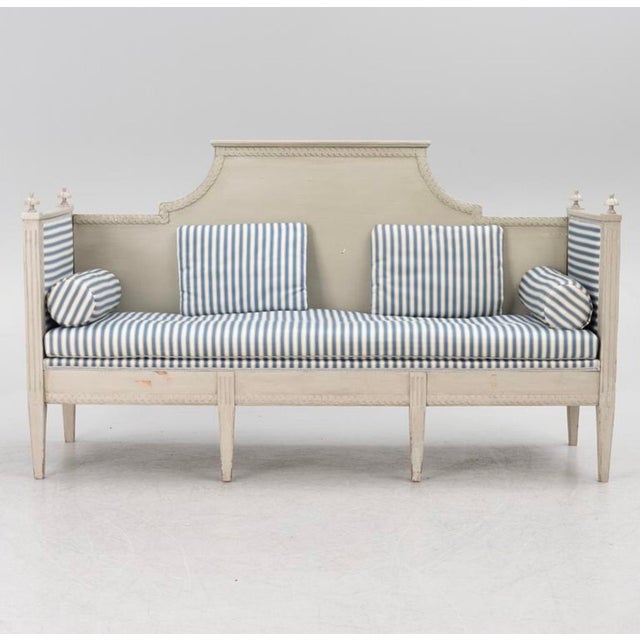 A useful and understated Swedish Gustavian sofa/bench. Later painted in a light grey blue and upholstered ina blue stripe...