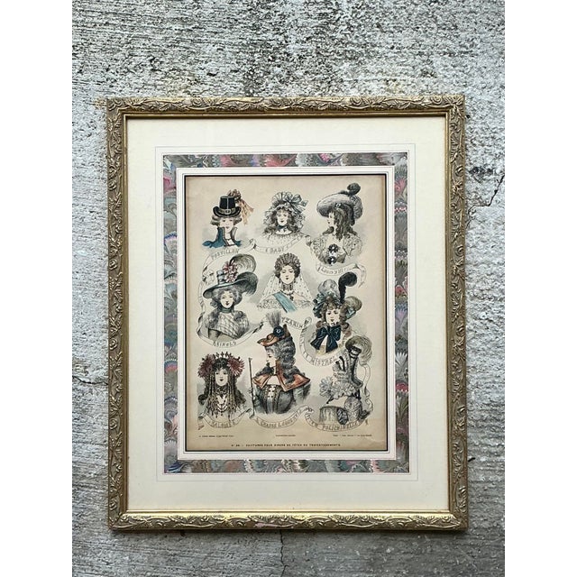 This enchanting French hand-colored engraving celebrates the whimsical and elaborate millinery of the late 18th century....