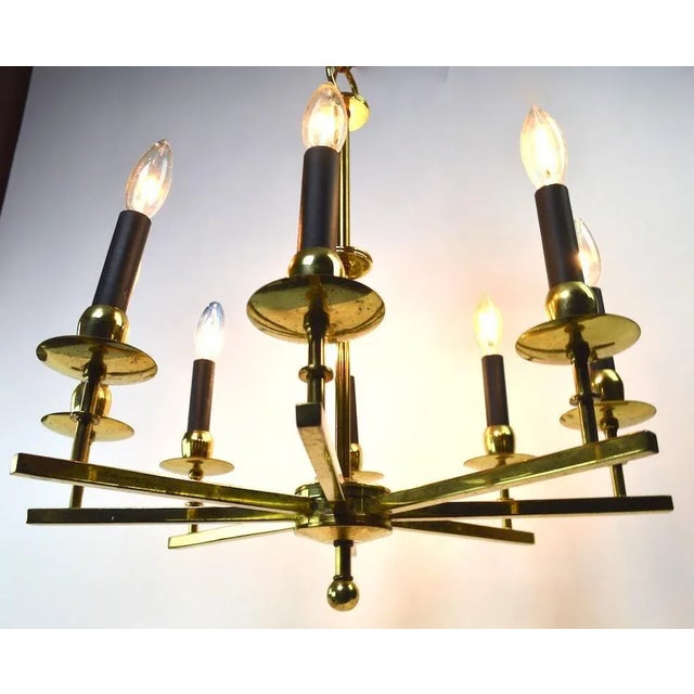 Stylish brass spoke style hanging fixture, in original and working condition. The chandelier shows some cosmetic wear to...