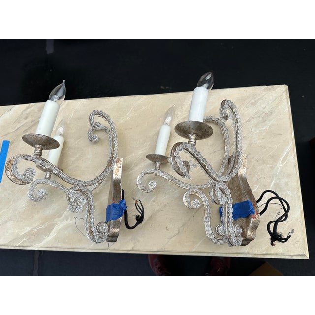 Custom two-arm Dennis & Leen sconces featuring a clear beaded frame and an antique silver leaf finish. Designed with...