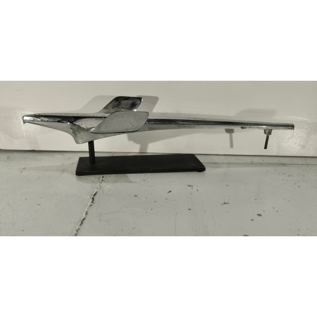 Vintage 50s auto hood ornament. Steel and chrome surface .mounted on a steel museum display. Streamlined airplane shape...
