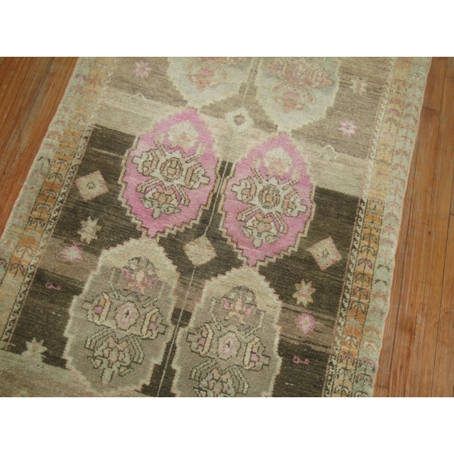 Turkish runner with a beige field, accents in browns and pink. Measures: 3'6" x 9'5".