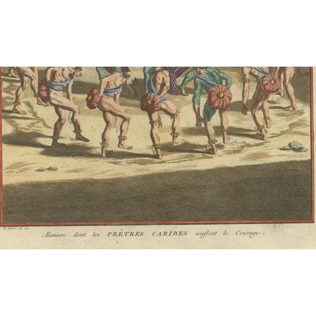 This hand-colored copperplate engraving titled “Manière dont les Prêtres Caribes soufflent le Courage” (The way Carib...
