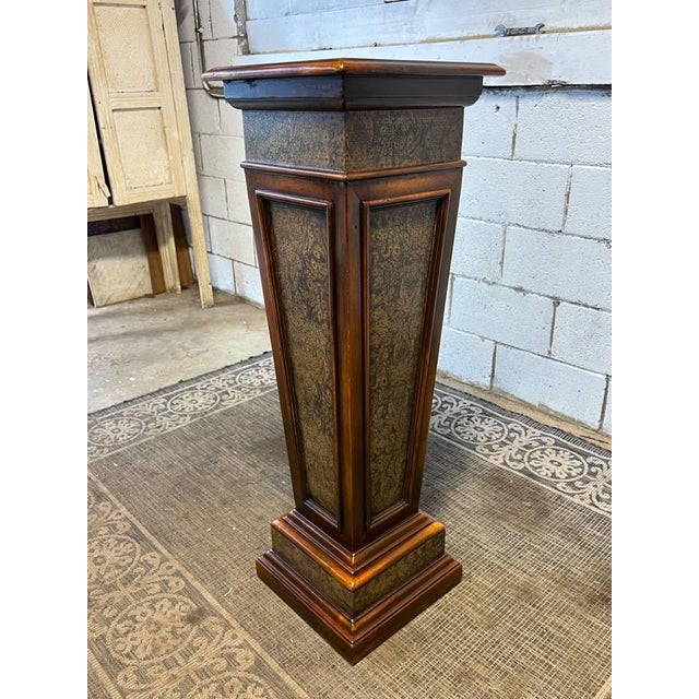 A Classical poplar burl panel tapered pedestal, with a square top and a stepped plinth base.