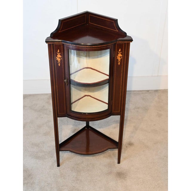 Agorgeous edwardian bow front corner cabinet features intricate inlay work in satinwood embedded into main mahogany...