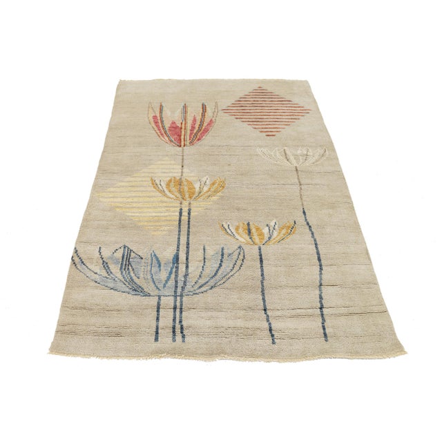 Elevate your space with this 4x6 modern Art Deco-inspired wool rug. It features a soft, neutral sand-colored field adorned...