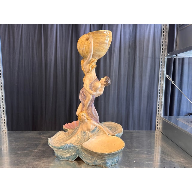An exceptional Italian Art Nouveau centerpiece in glazed ceramic, dating to around 1900. This remarkable sculptural...
